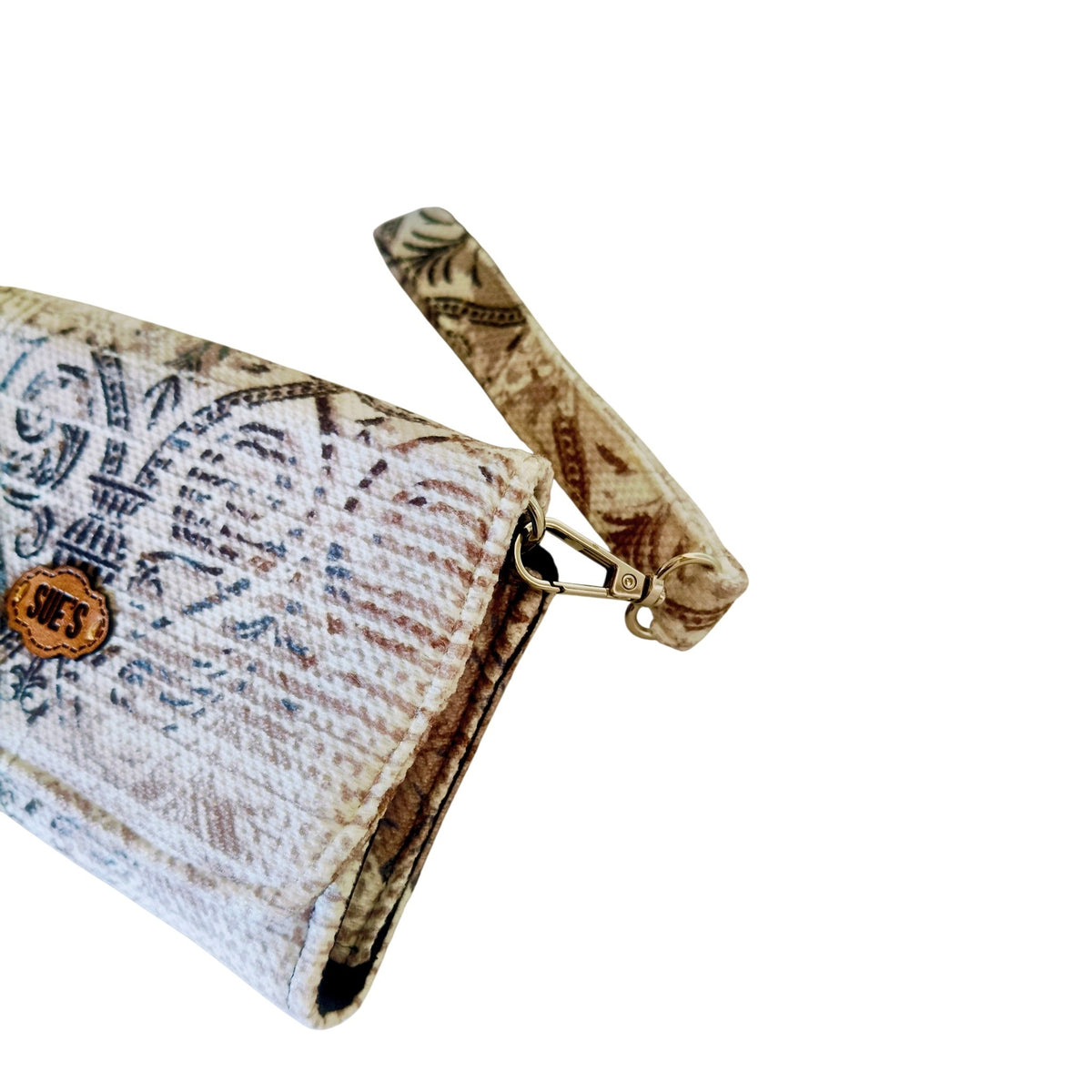 Suepatchwork large wallet with Arabic-inspired patterns, featuring a detachable wrist strap and a branded leather tag.