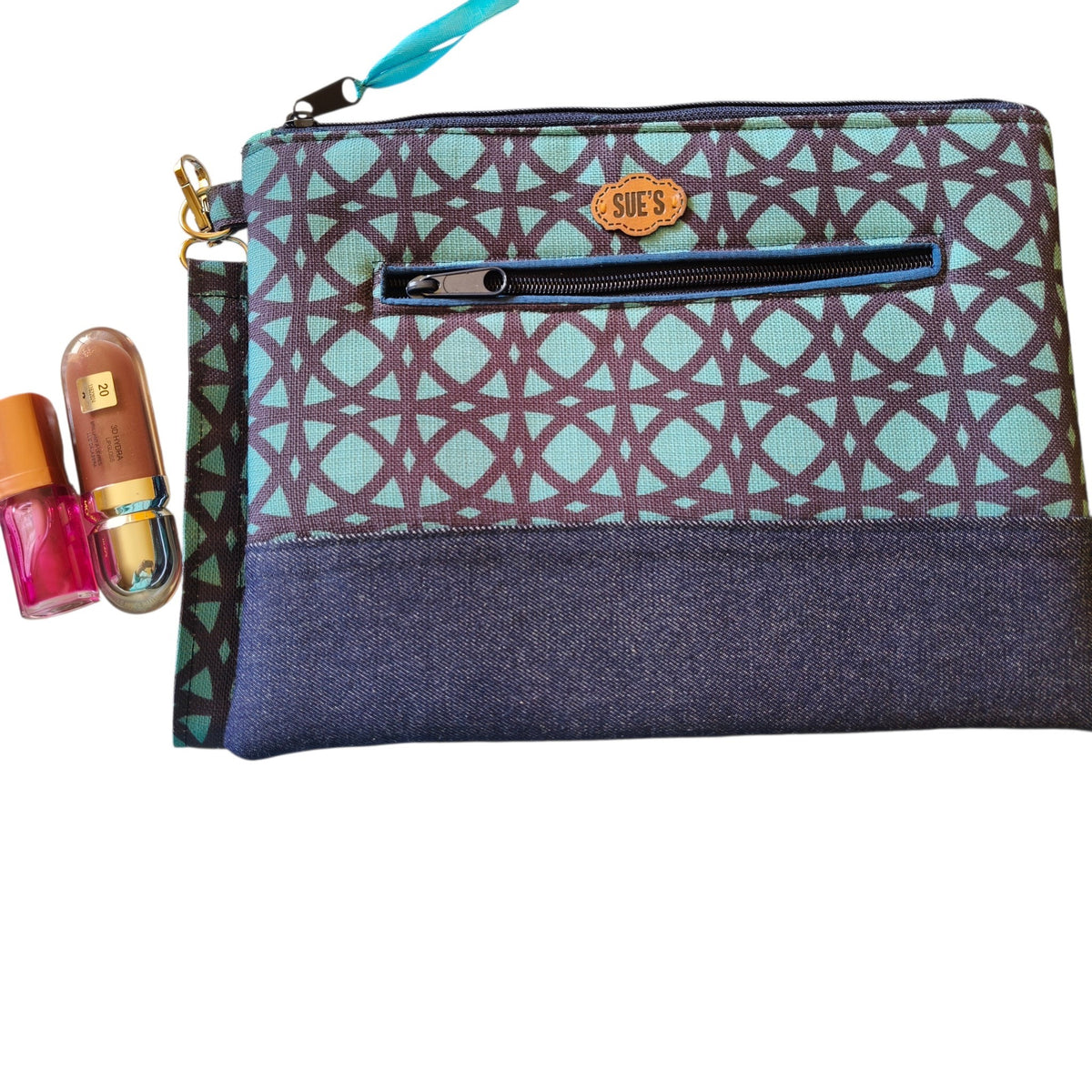 Suepatchwork Asalah handmade clutch in teal and dark blue geometric fabric with a front zip pocket and wrist strap