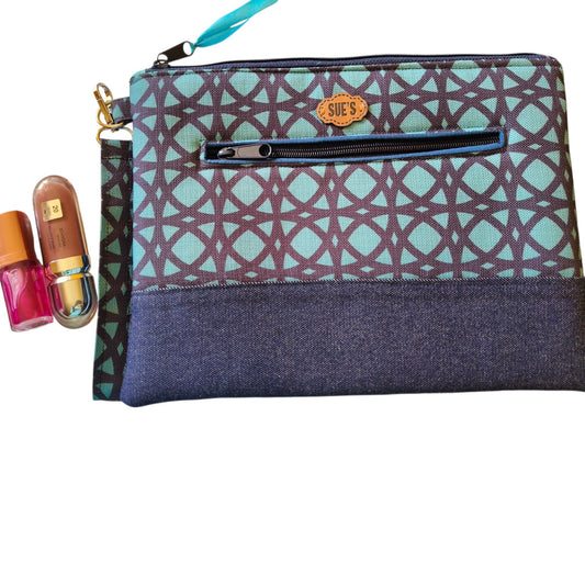 Suepatchwork Asalah handmade clutch in teal and dark blue geometric fabric with a front zip pocket and wrist strap
