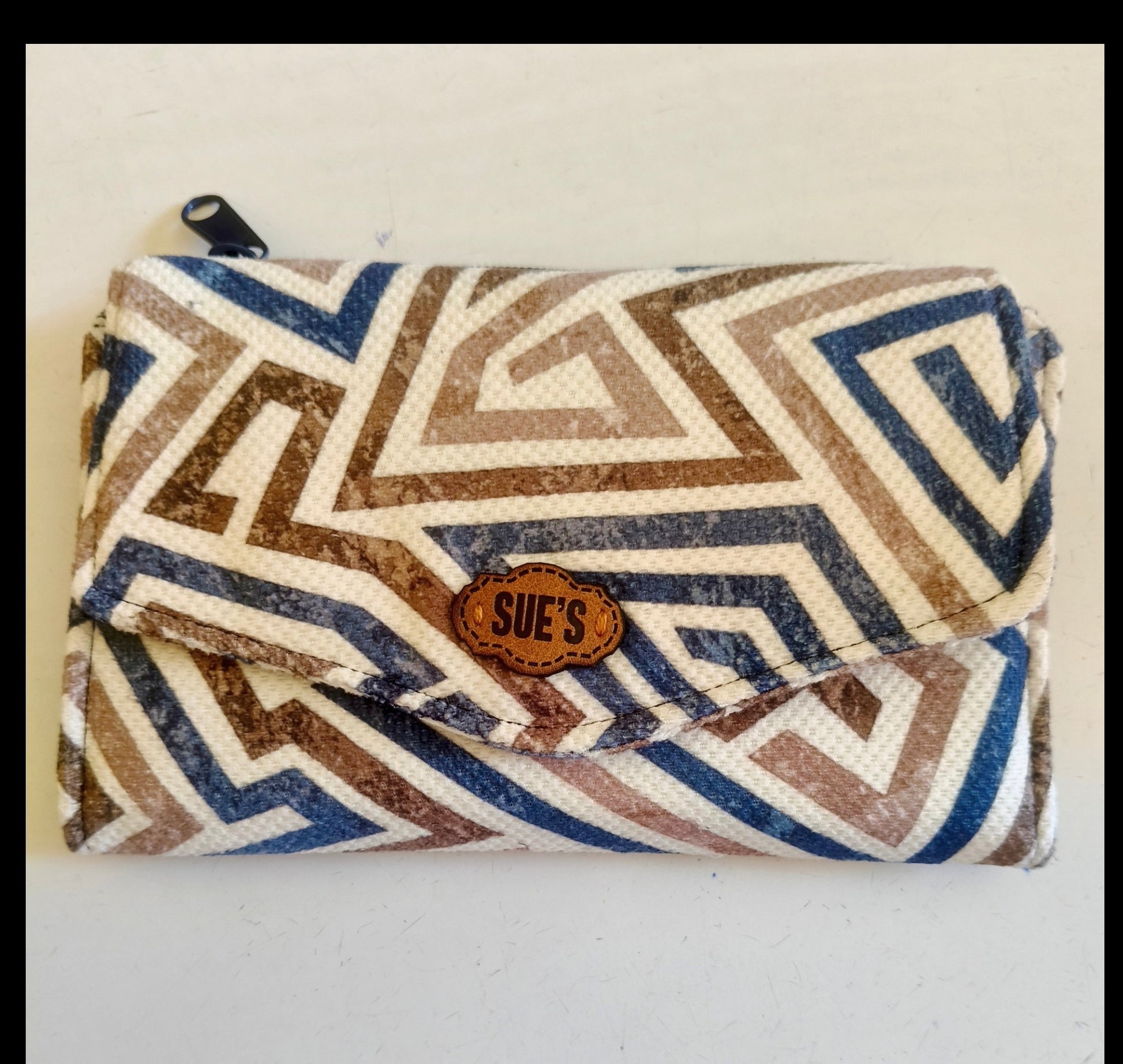 Suepatchwork blue and brown geometric print fabric trifold wallet with a leather logo tag and zip closure