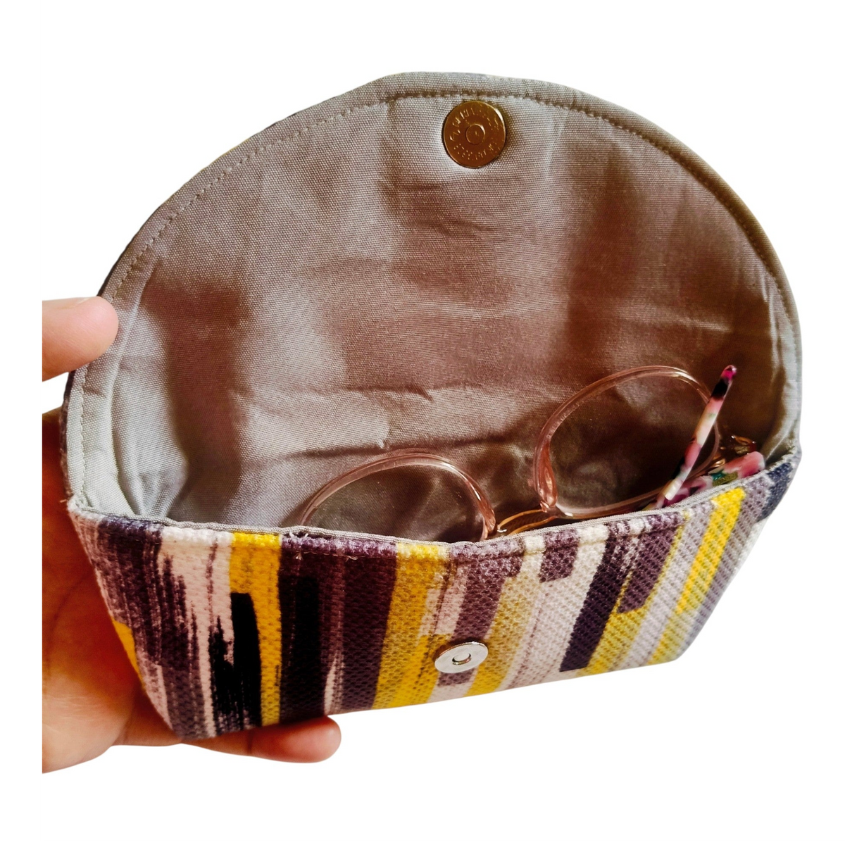 Suepatchwork handcrafted fabric glasses case with yellow and grey abstract print, magnetic closure, and soft lining.
