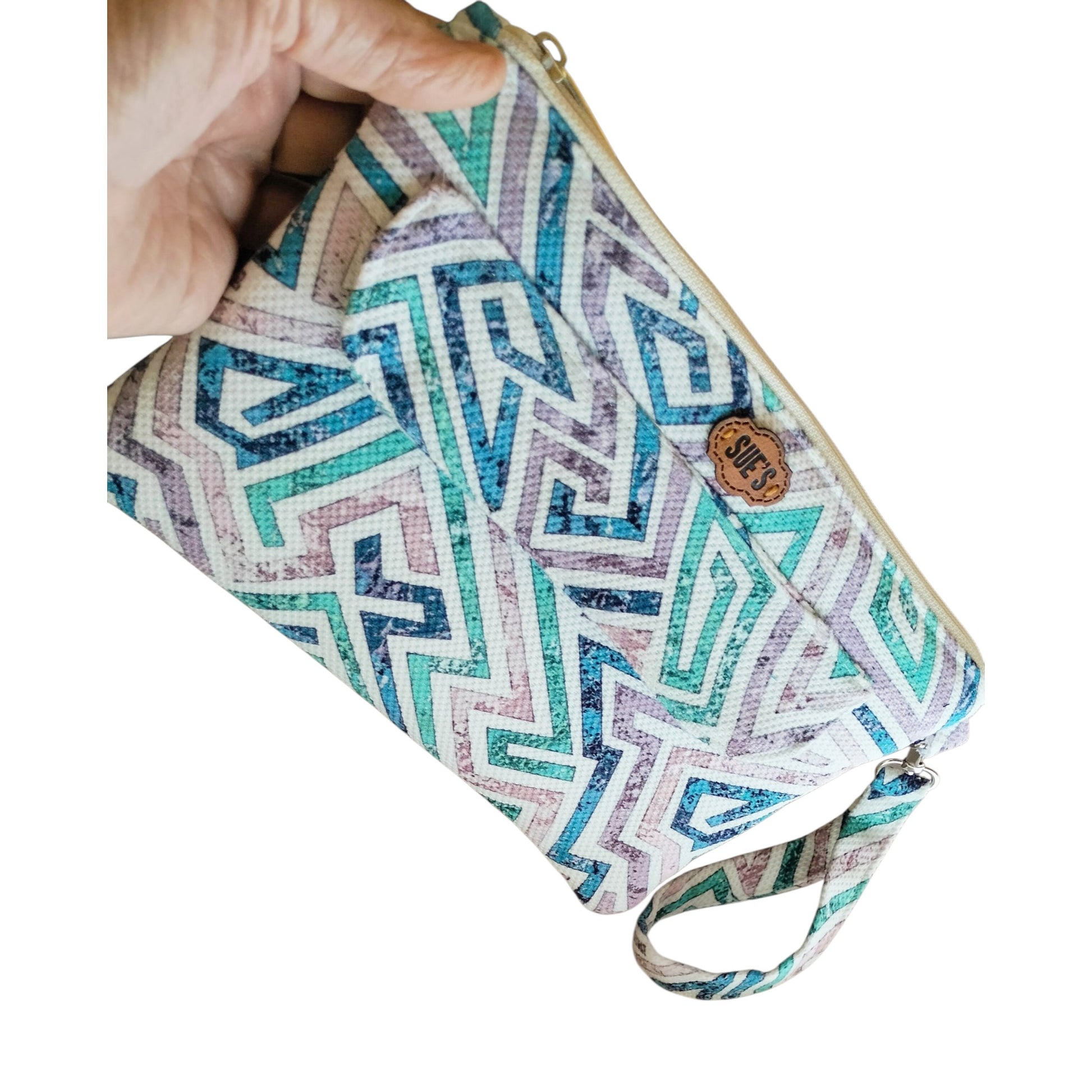Suepatchwork handmade fabric clutch with geometric teal and purple pattern, featuring an external zip pocket.
