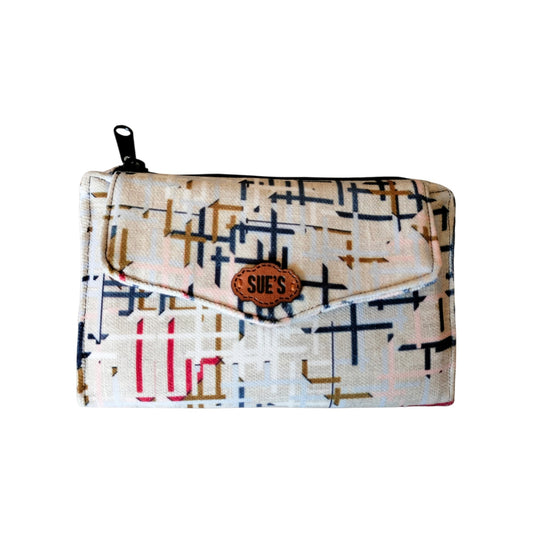 Suepatchwork trifold wallet in cream fabric with a geometric grid pattern, featuring a leather logo and zipper pocket.