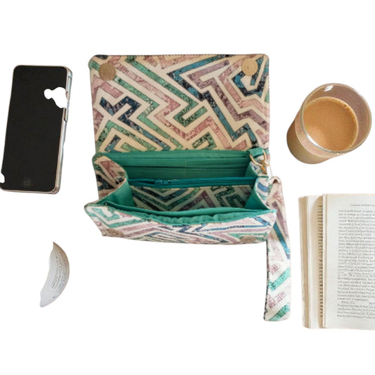 Suepatchwork handcrafted fabric wallet with geometric print, teal lining, detachable strap, and internal zip pocket.
