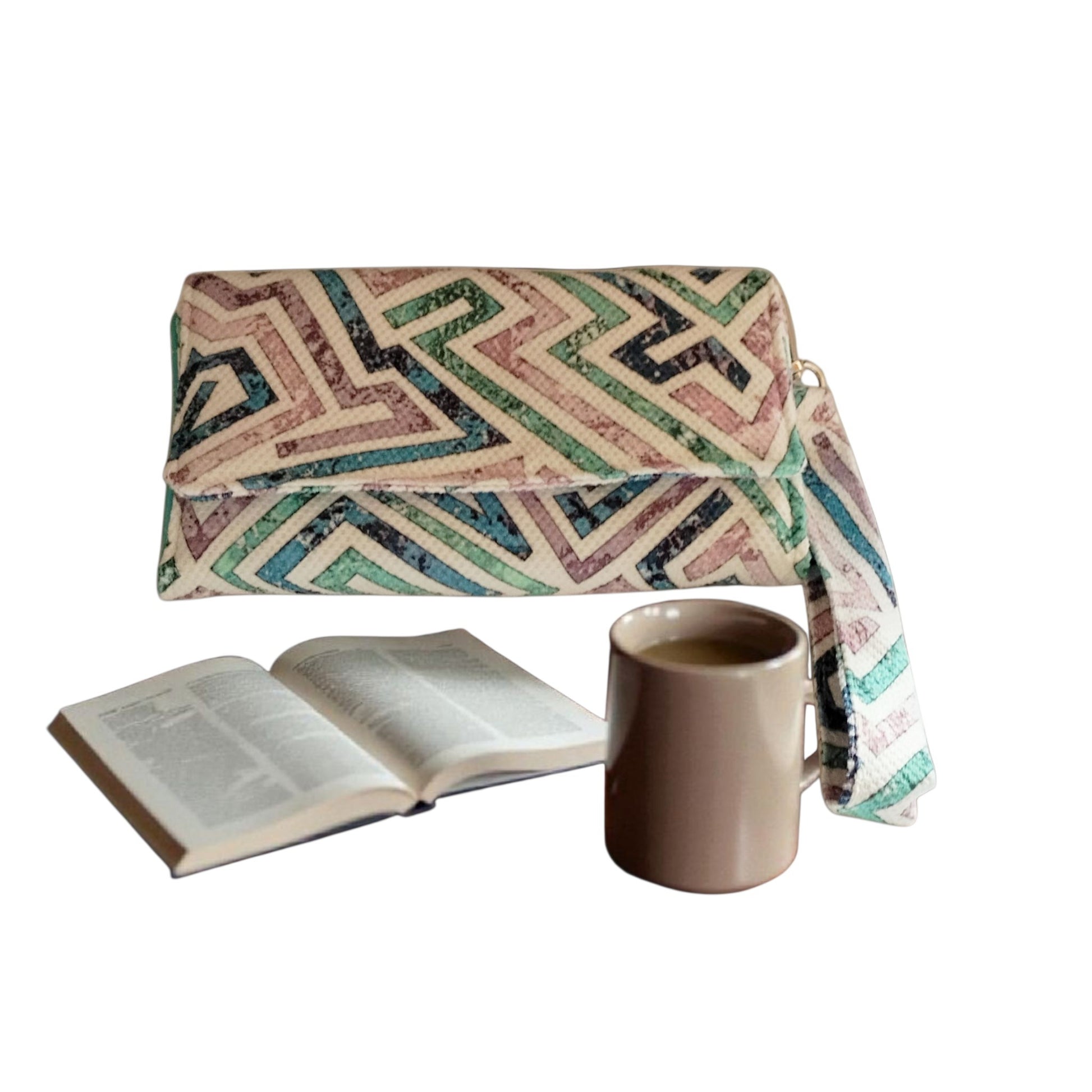 Suepatchwork handcrafted fabric wallet with geometric print, detachable strap, open book, and coffee mug on table