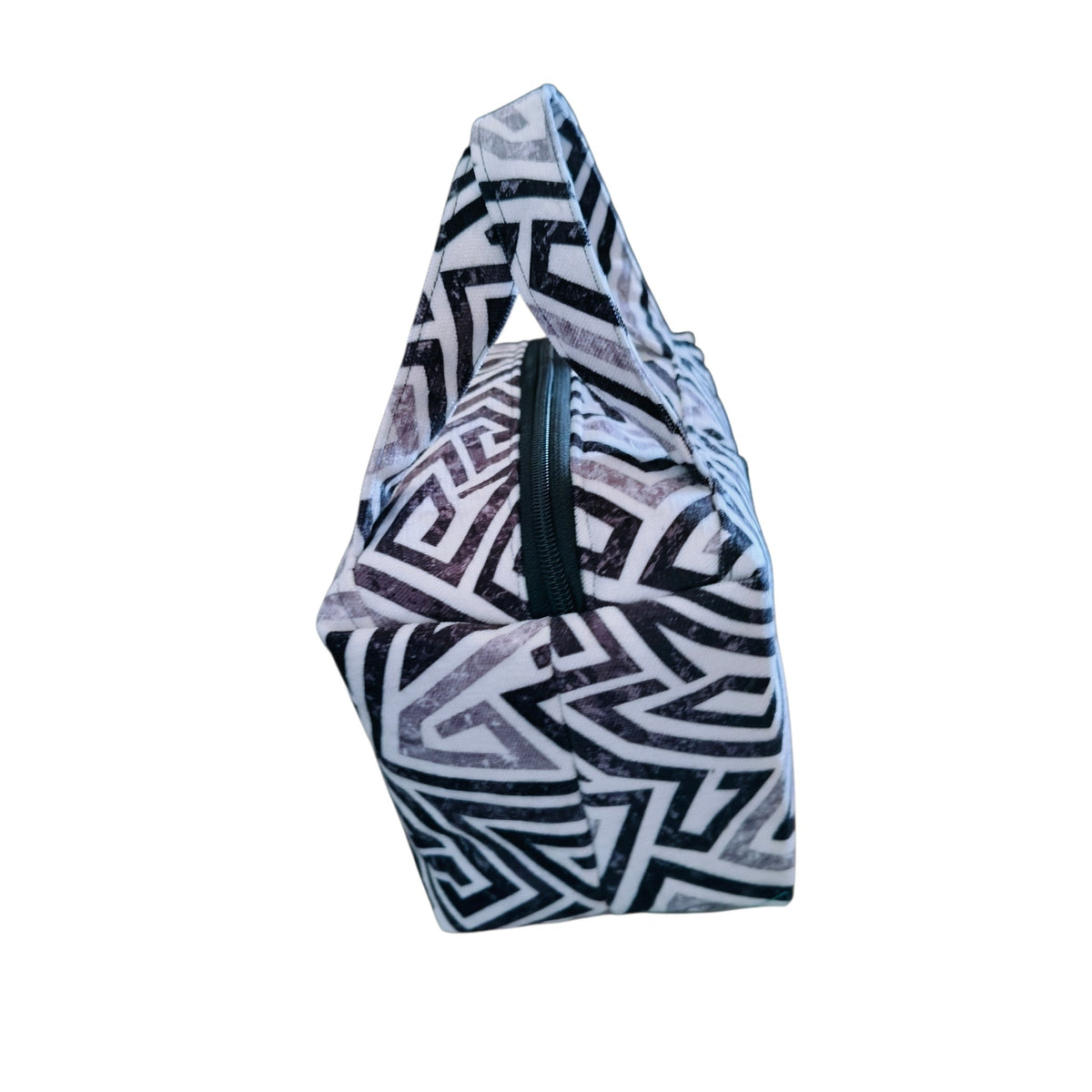 Suepatchwork handmade makeup bag in black and white geometric fabric with a sturdy handle and secure zip closure.