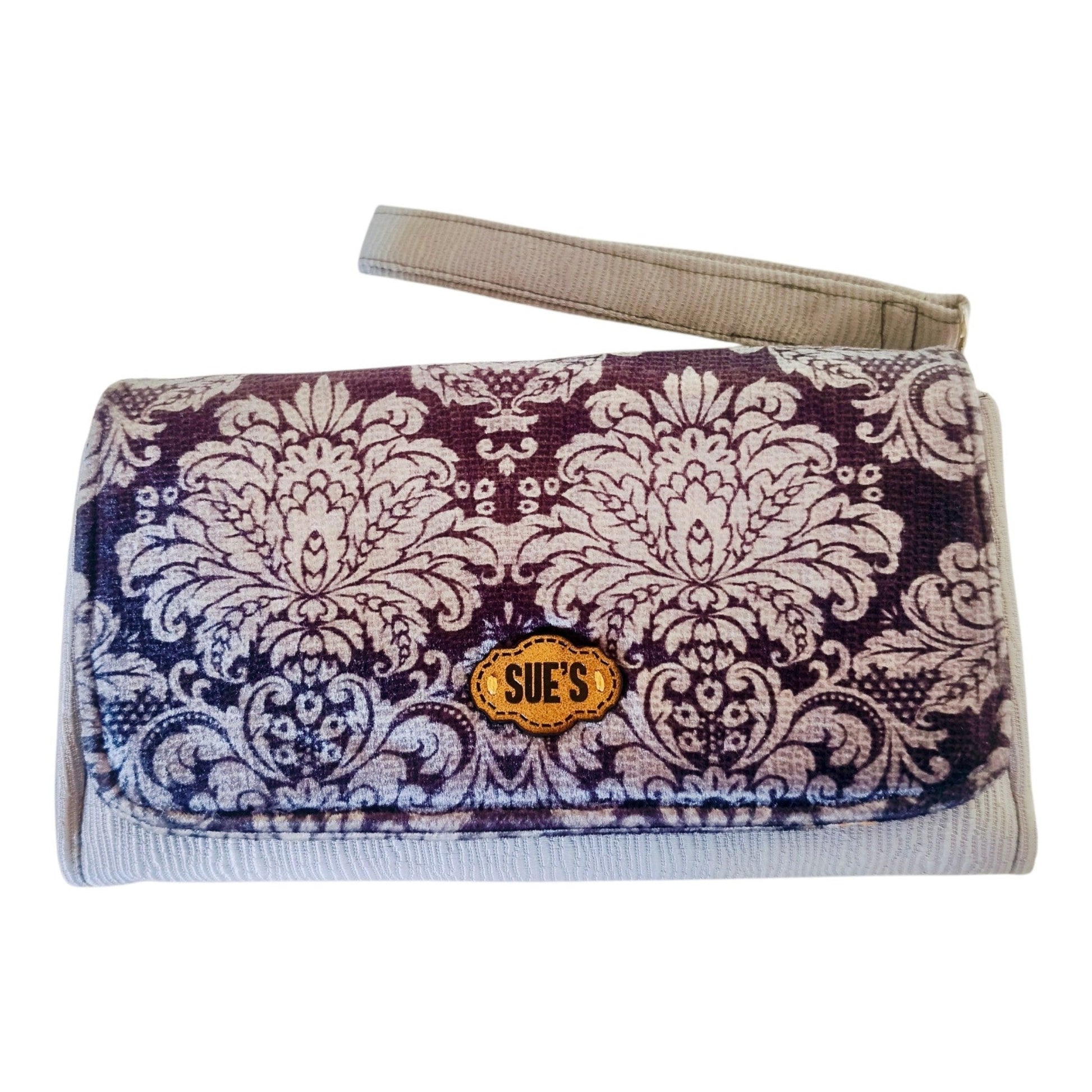Suepatchwork gray damask print large wallet with wrist strap and branded leather tag on a marble surface