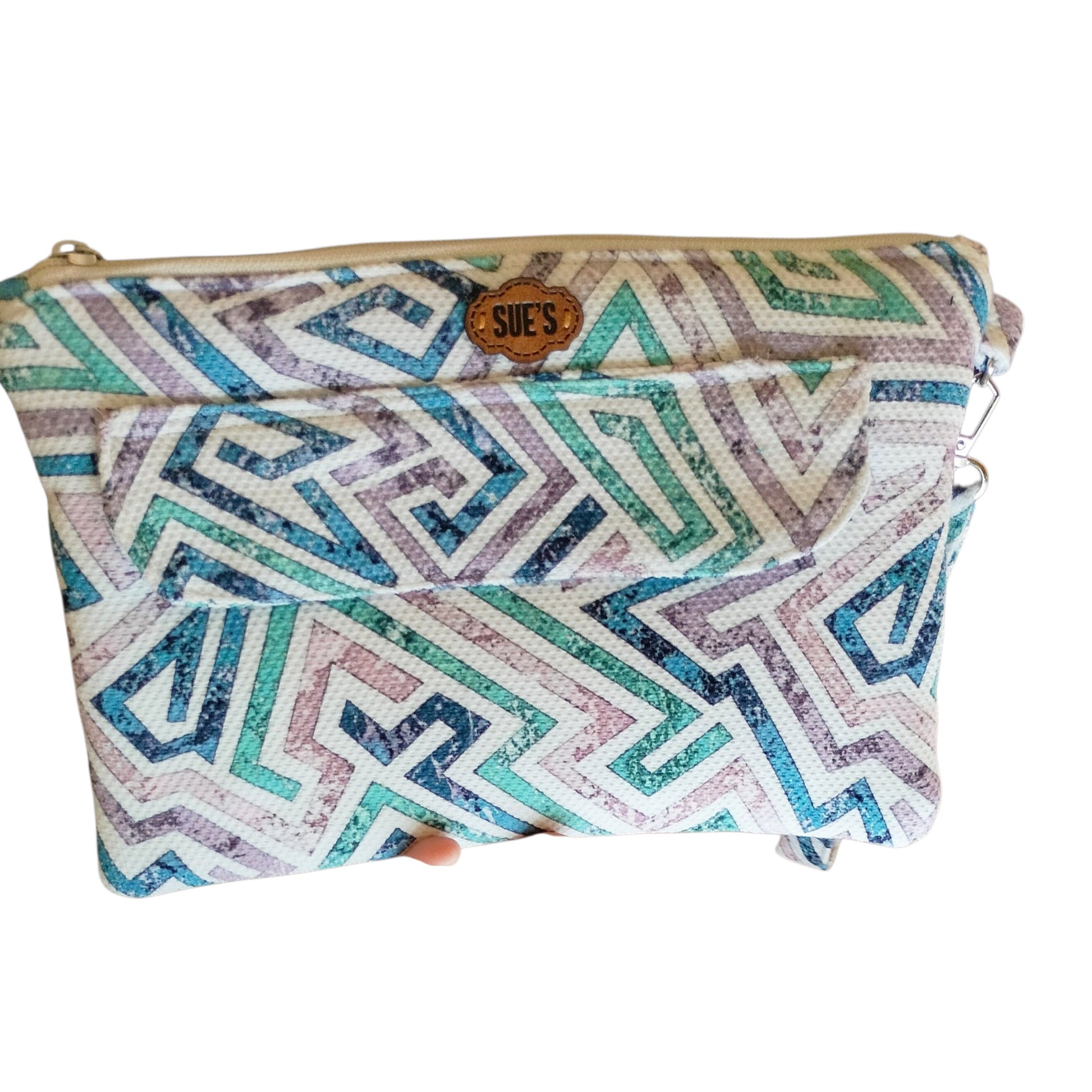Suepatchwork handmade fabric clutch with a geometric blue, purple, and teal pattern and an external zip pocket.