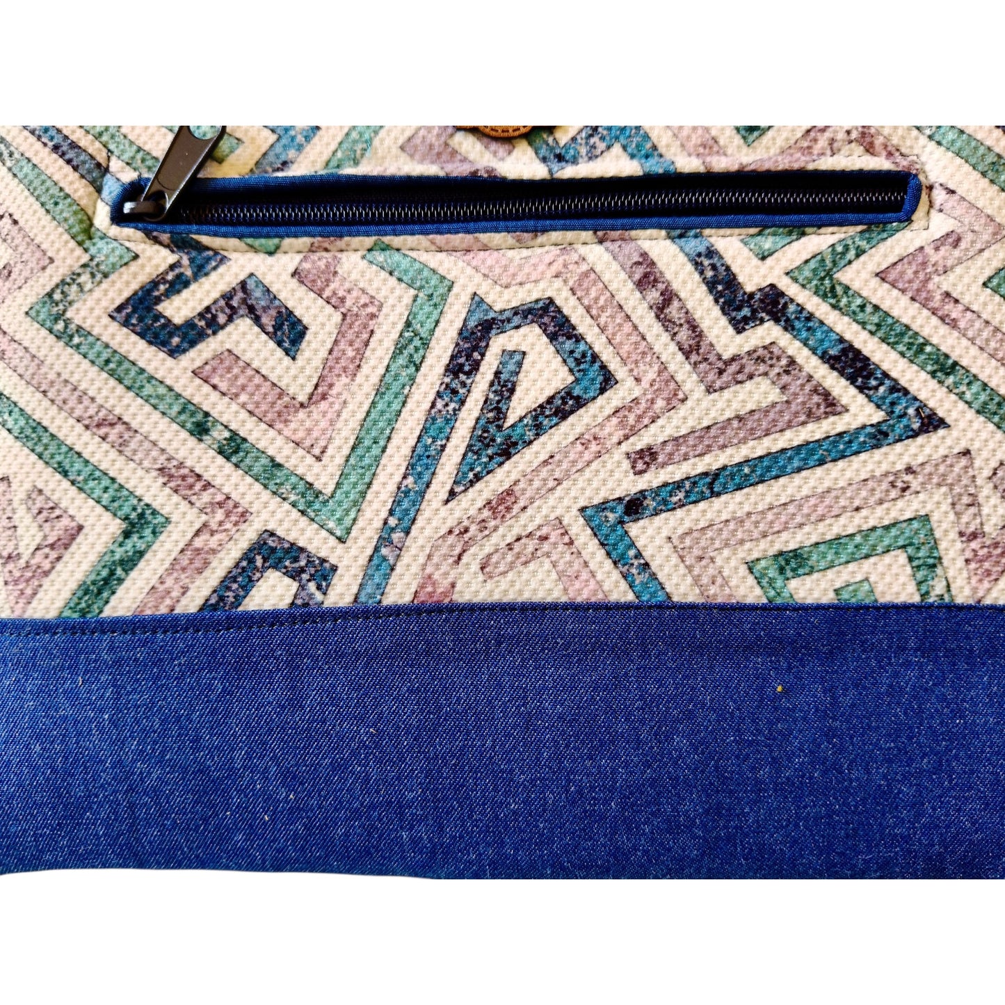 Suepatchwork Lamsa handmade clutch featuring geometric patterned fabric with a blue denim zip pocket detail.