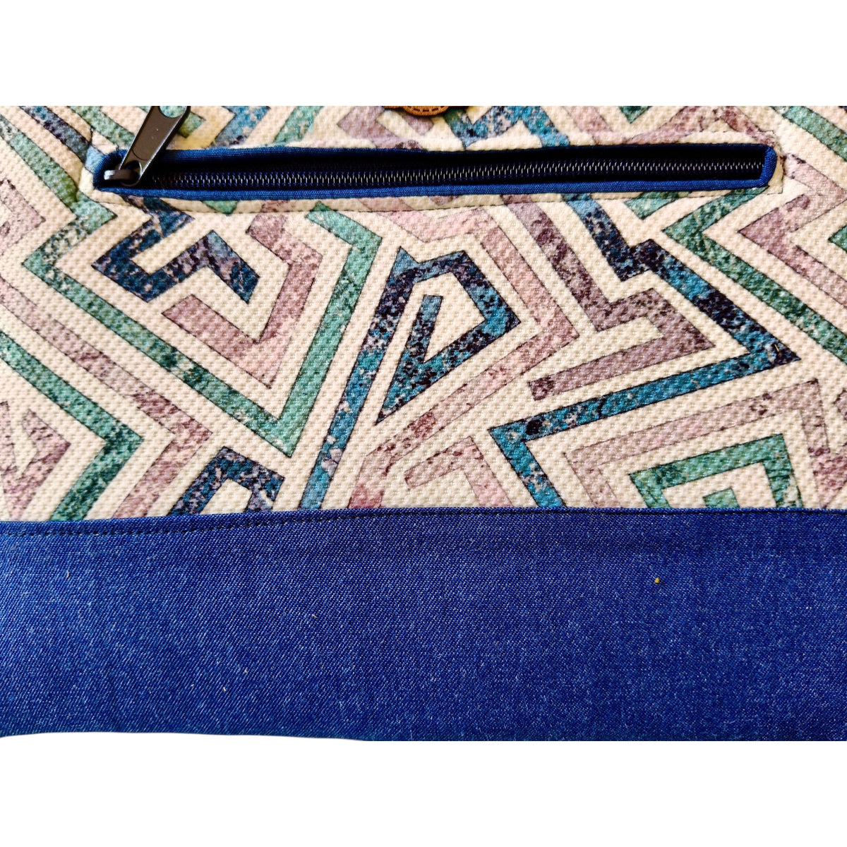 Suepatchwork Lamsa handmade clutch featuring geometric patterned fabric with a blue denim zip pocket detail.