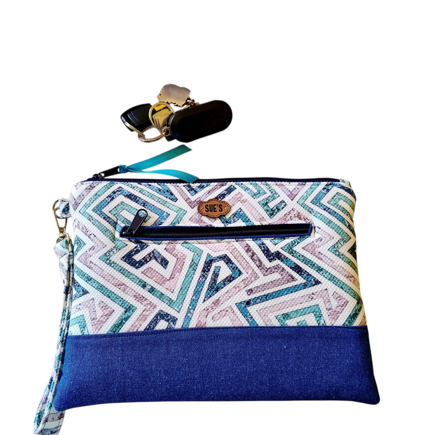 Suepatchwork Lamsa handmade clutch featuring a geometric patterned fabric, blue denim base, and external zip pocket.