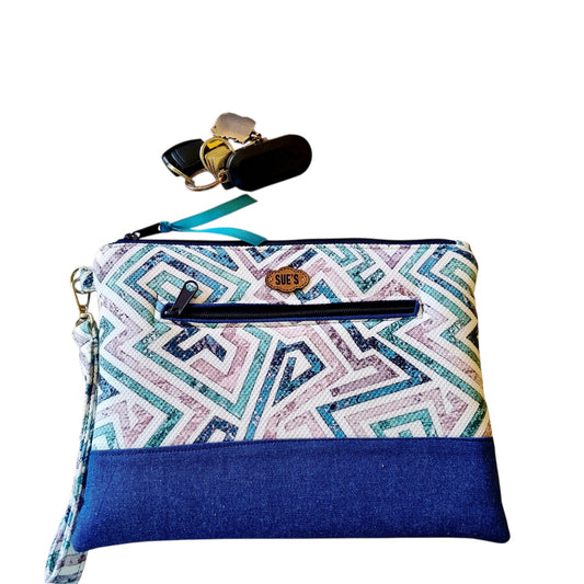 Suepatchwork Lamsa handmade clutch featuring a geometric patterned fabric, blue denim base, and external zip pocket.