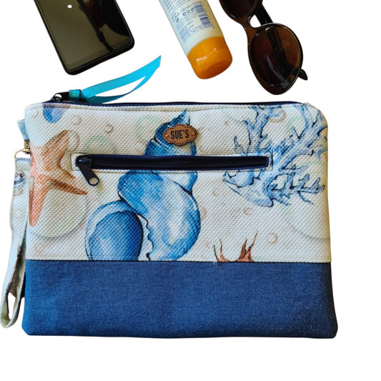 Suepatchwork Nesma handmade clutch featuring a blue seashell print, denim base, and an exterior zip pocket.