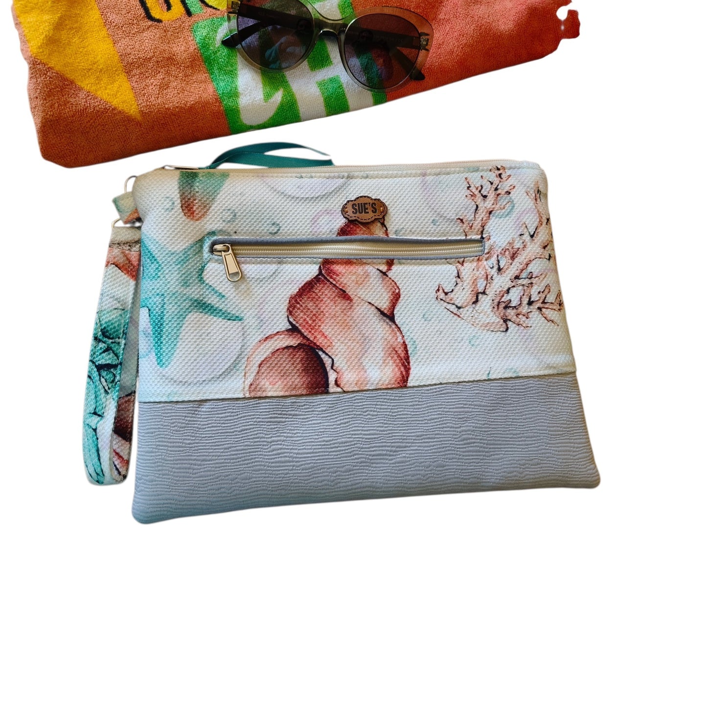 Suepatchwork Nesma 2 handmade clutch featuring a seashell print, grey textured base, and an external zip pocket.