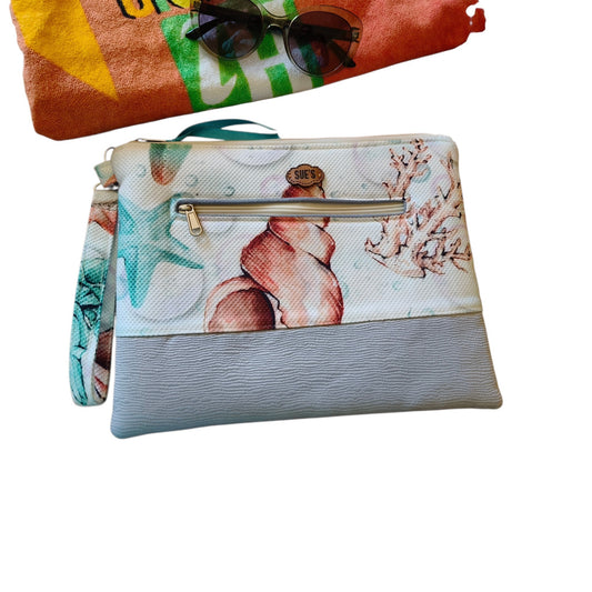 Suepatchwork Nesma 2 handmade clutch featuring a seashell print, grey textured base, and an external zip pocket.