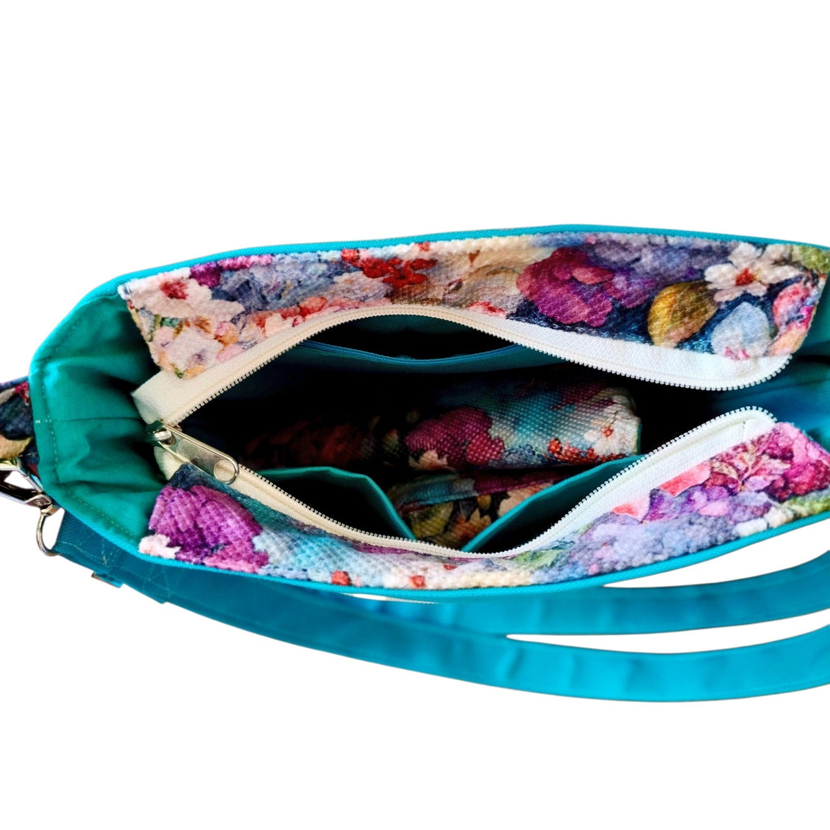 Suepatchwork Rose garden crossbody bag interior view with teal fabric, floral lining, and organized zip pockets.
