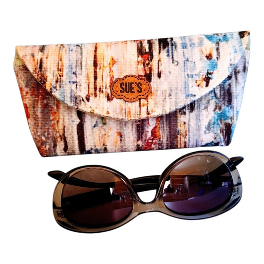Suepatchwork handmade fabric glasses case with a colorful scrambled pattern and a branded leather logo tag