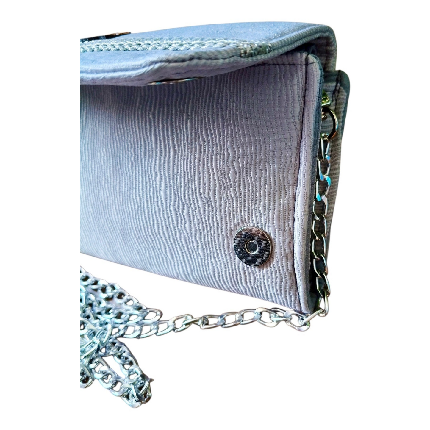 Suepatchwork silver evening wallet with detachable metal chain strap, featuring textured fabric and side snap detail.