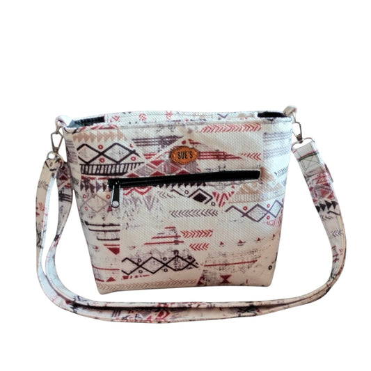 Suepatchwork white geometric patchwork crossbody bag with an adjustable strap and external zip pocket.