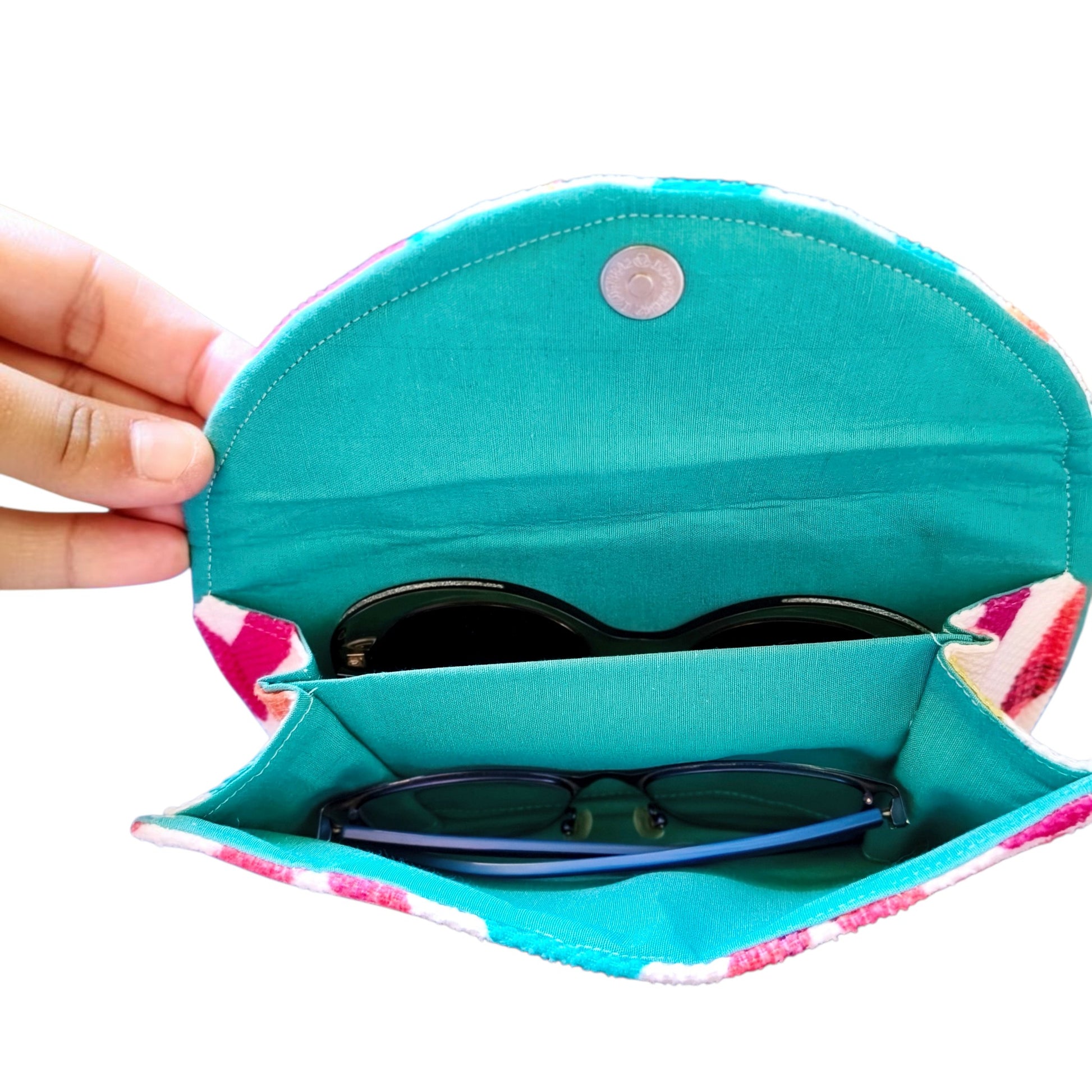 Suepatchwork handmade fabric double glasses case in teal with a colorful zigzag pattern holding two pairs of glasses