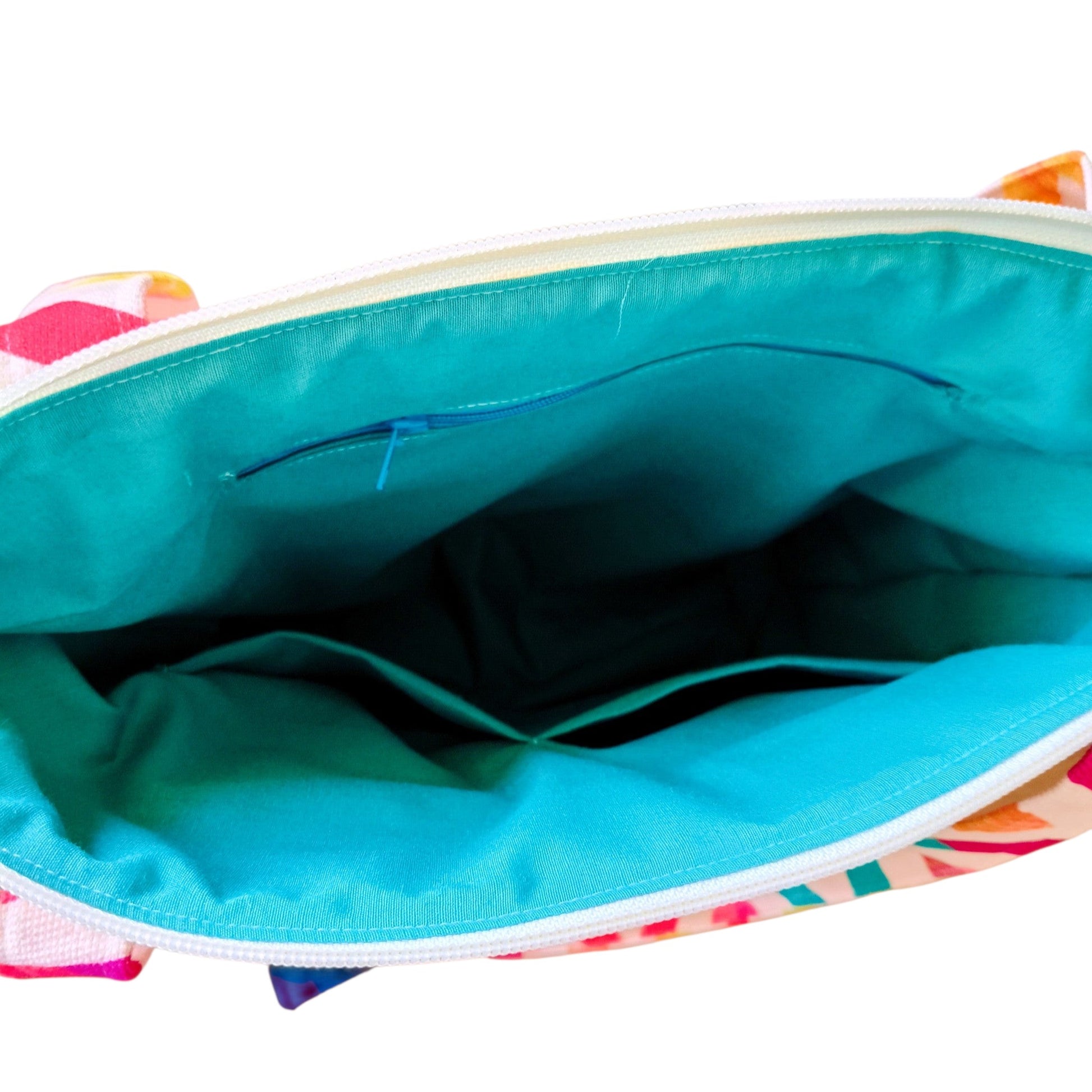 Suepatchwork zigzag tote bag interior featuring bright turquoise cotton lining, zip pocket, and divided compartments.